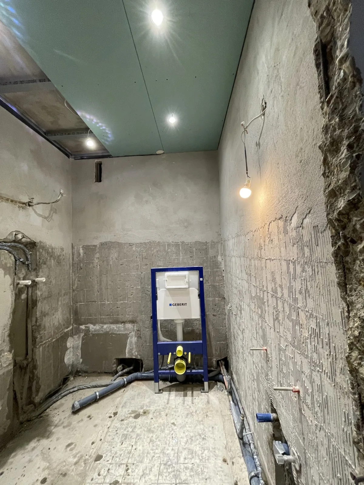 Badezimmer im Rohbau mit offenen Wänden und Vorwandelement vor der Sanierung